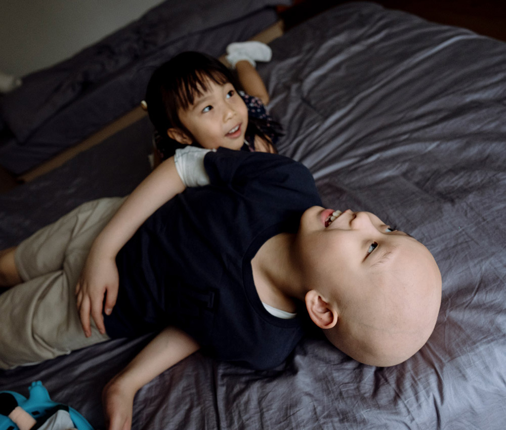 Siblings Playing On Bed